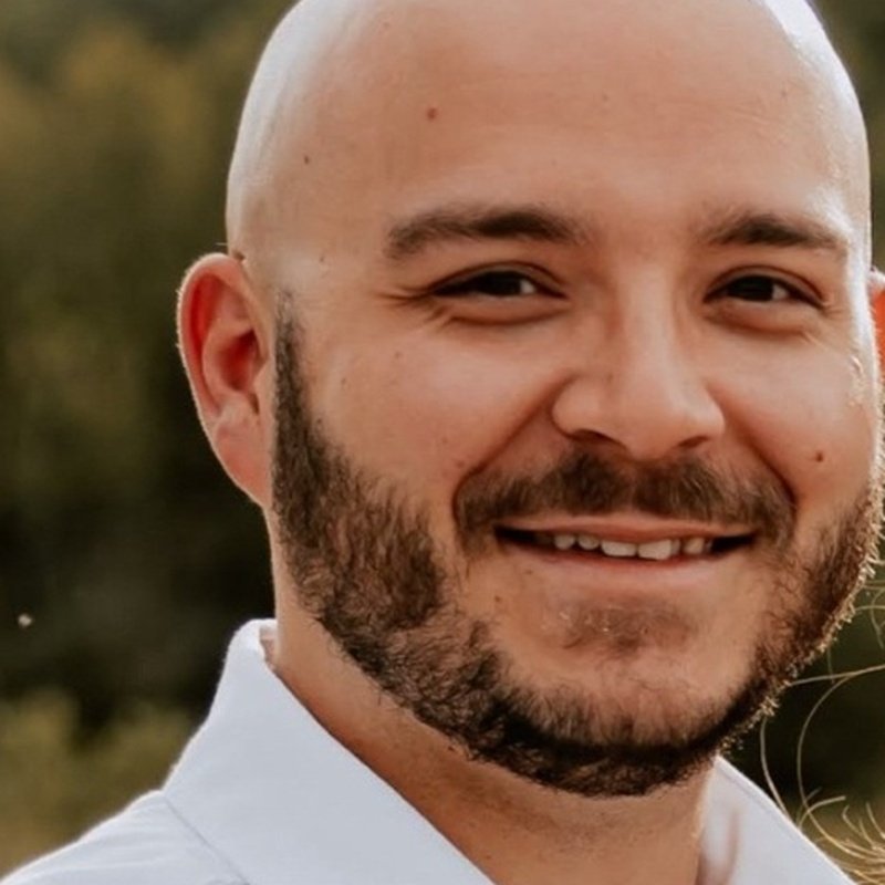 Tito, founder of Tap Into Titos, smiling outdoors
